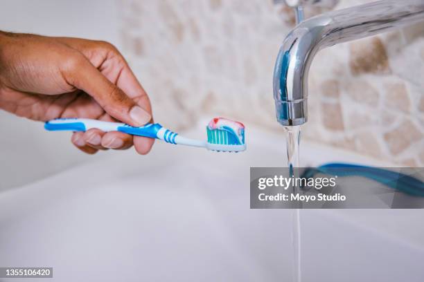 aufnahme einer nicht erkennbaren person beim zähneputzen in einem badezimmer zu hause - bathroom clean closeup stock-fotos und bilder