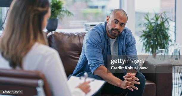 cropped shot of a handsome young man looking thoughtful while sitting in session with his female therapist - smirnoff vodka and visionaire host the screening and after party of sleeping with other people stockfoto's en -beelden