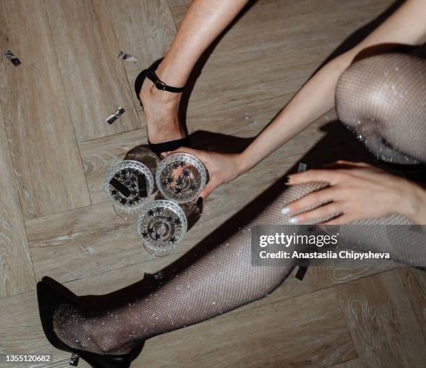 3 glasses on the floor in female hands - elegant cocktail party stockfoto's en -beelden