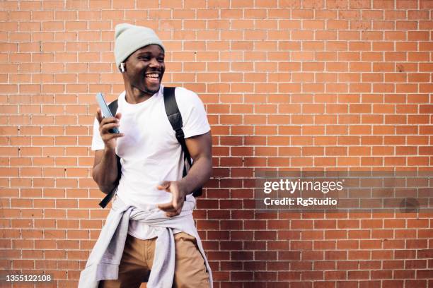 african american young man on vacation enjoying music on the street - young men dance stock pictures, royalty-free photos & images