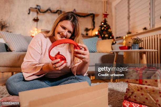 woman got headphones for christmas - christmas gift stock pictures, royalty-free photos & images