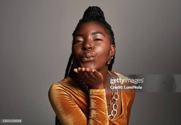 shot of a beautiful young woman posing against a grey background - blowing a kiss stock pictures, royalty-free photos & images