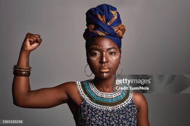 studioaufnahme einer schönen jungen frau in traditioneller afrikanischer kleidung - art for social justice stock-fotos und bilder