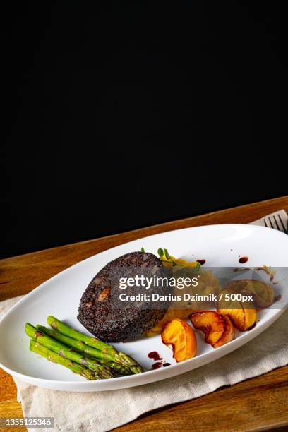 close-up of food in plate on table against black background - soße stock pictures, royalty-free photos & images