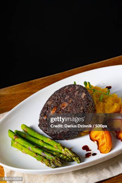 close-up of food in plate on table against black background - gemüse grün stock pictures, royalty-free photos & images