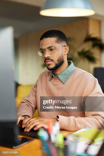 businessman using desktop pc at home office - focus noir photos et images de collection