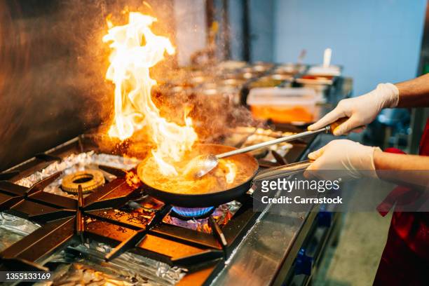 frying pan on the stove with a large flame of fire - big cook 個照片及圖片檔