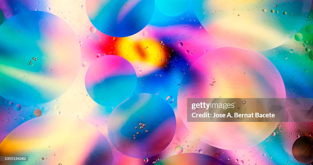 Full frame of spots and bubbles of liquid floating on a surface of water.
