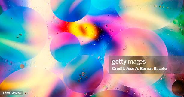 full frame of spots and bubbles of liquid floating on a surface of water. - colourful background stock pictures, royalty-free photos & images