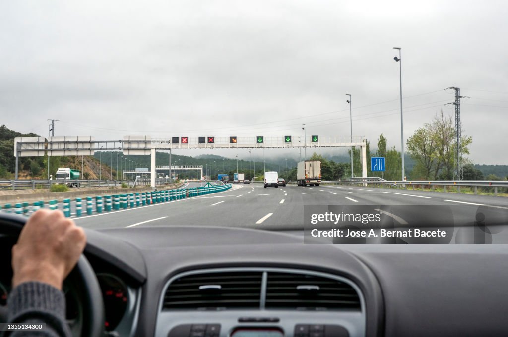 Car point of view, luminous signs on a highway to regulate traffic in a tunnel area.