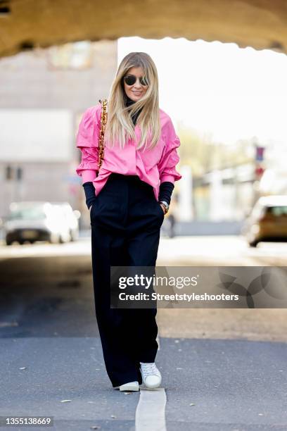 Influencer Gitta Banko, wearing black pants and a black turtleneck by Max Mara, a pink colored blouse by Boscana, white sneakers by Saint Laurent and...