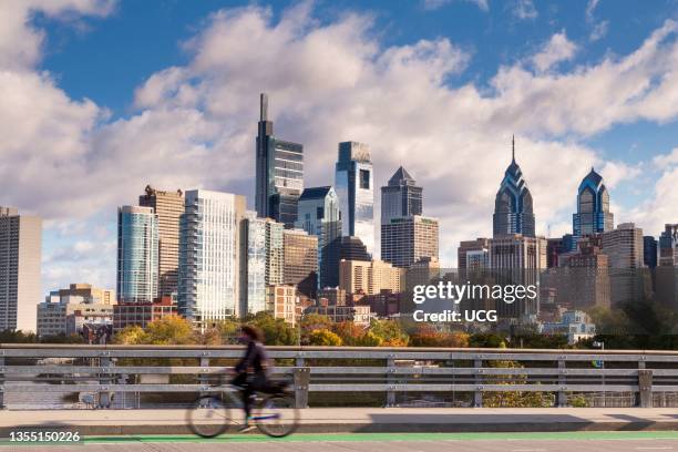 Skyline with cyclist on South Street Bridge at Sunset, Philadelphia, Pennsylvania, USA.