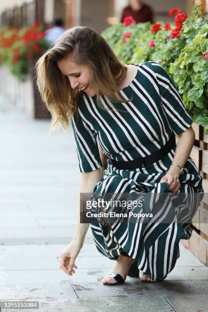 young elegant woman in striped maxi dress dropped her phone on the sidewalk - portrait looking down stock pictures, royalty-free photos & images