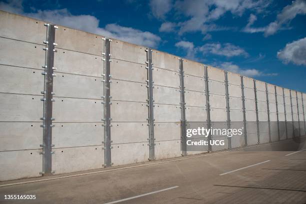 Southampton, England, UK, A long high security wall of concrete panels bolted together.