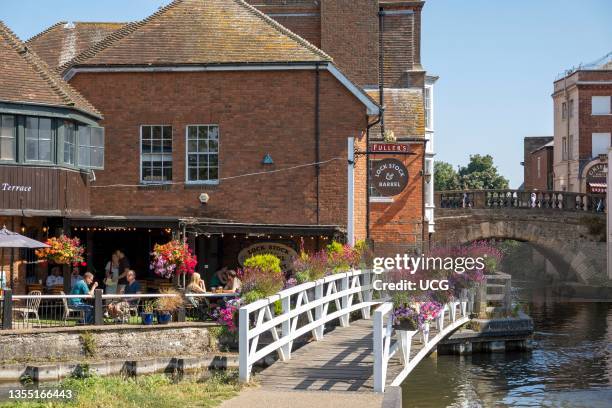 Newbury, Berkshire, England, UK, Landscape looking toward the old town bridge and a pub with floral display alongside the Kennet and Avon canal in...