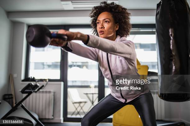 mujer haciendo ejercicio de levantamiento de pesas - levantamento de peso fotografías e imágenes de stock