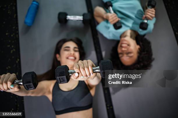 two woman doing exercises with dumbbells together - gym friends stock pictures, royalty-free photos & images
