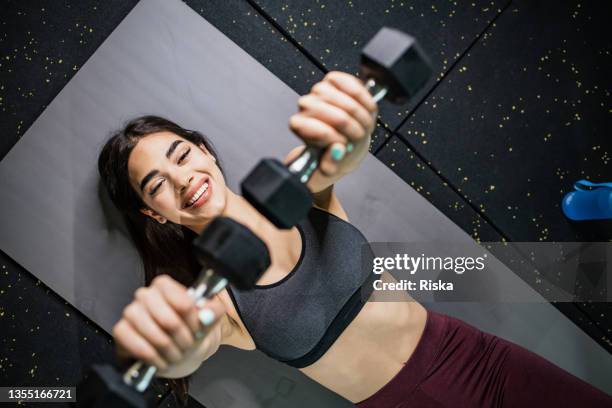 visão de ângulo alto de uma mulher fazendo exercício com haltere - tatame equipamento para exercícios - fotografias e filmes do acervo