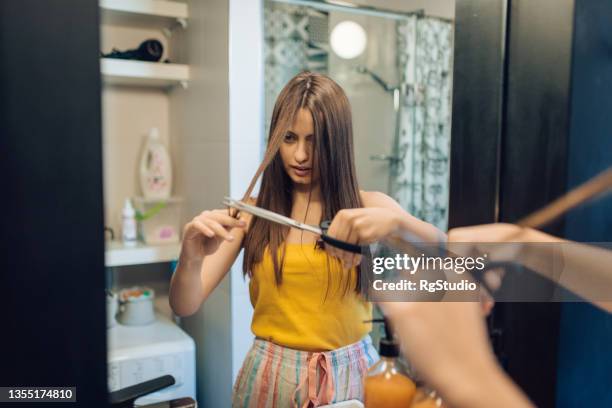 girl doing herself hairstyle at home - cortar cabelo imagens e fotografias de stock