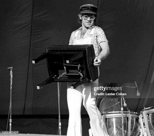 English singer, pianist and composer Elton John moves his piano chair on stage during the West of the Rockies tour on October 25, 1975 at Dodger...