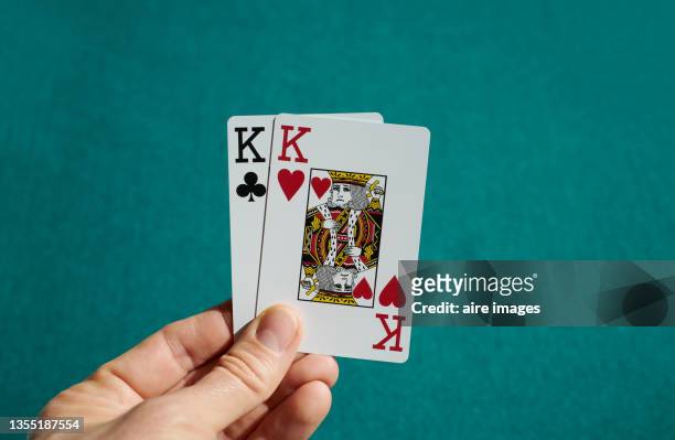 close-up of cards held in a human hand with two kings - casino tables hands stock pictures, royalty-free photos & images