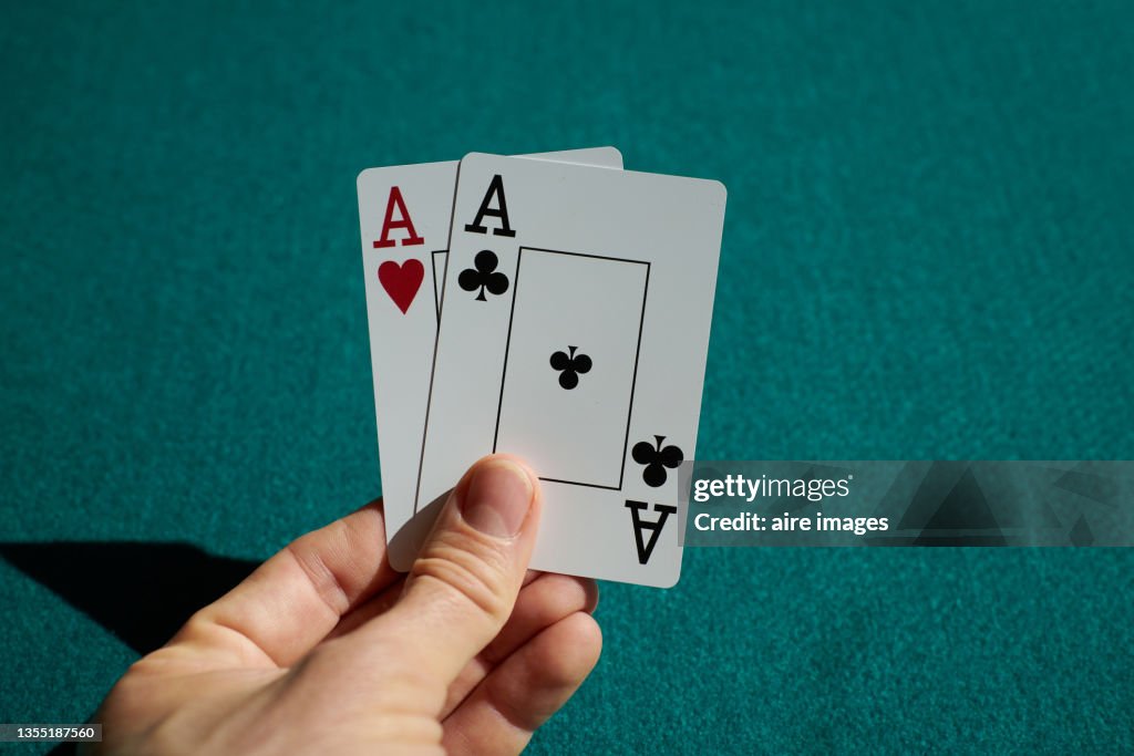 Close-up shot of playing cards held in a human hand two aces