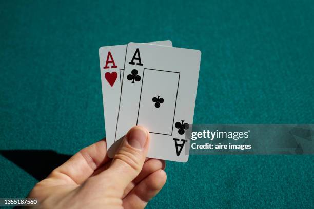 close-up shot of playing cards held in a human hand two aces - carta de baralho imagens e fotografias de stock