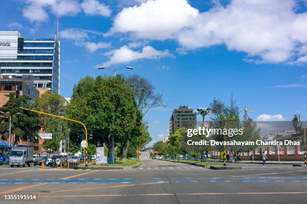 bogota, colombia - a city blue bus on carrera 11 where it cuts across calle 100 in the south american capital city. morning sunlight clear blue sky - car and motorcycle on mountain road stock pictures, royalty-free photos & images