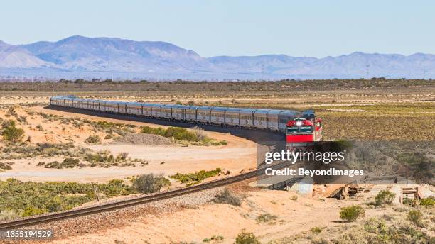 long distance luxury passenger train with red engine in outback south australia with flinders ranges backdrop - darwin stockfoto's en -beelden