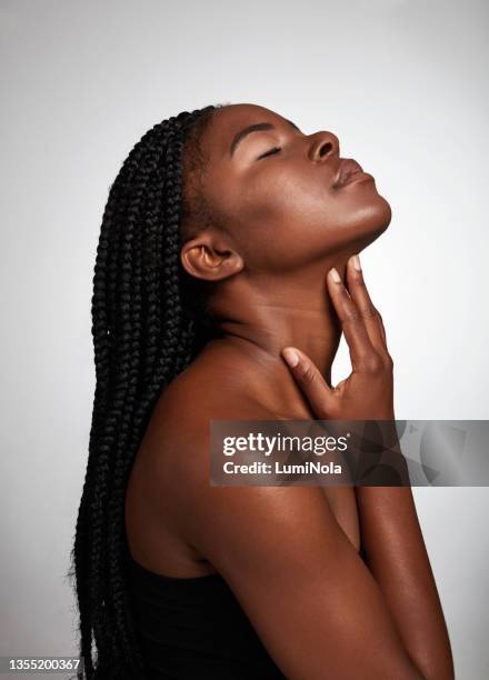 studio shot of an attractive young woman posing against a grey background - human skin background stock pictures, royalty-free photos & images