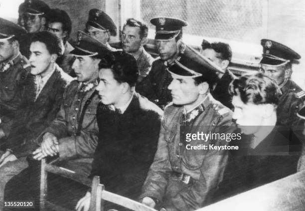 Guards sitting in a courtroom with some of the youths accused of storming the prison and a militia post during an anti-Communist uprising in Poznan,...