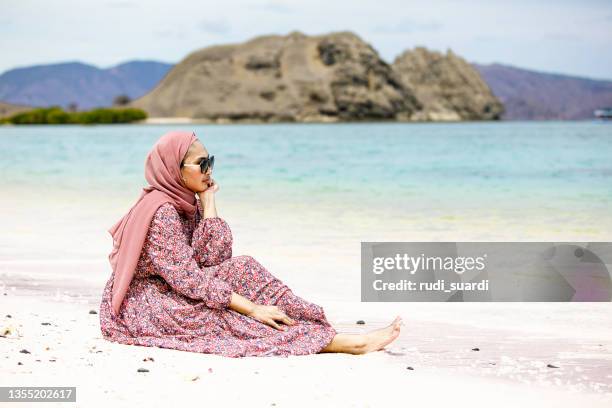 young asian woman enjoy vacation at pink beach in padar island, labuan bajo, nusa tenggara timur - muslim woman beach stock pictures, royalty-free photos & images