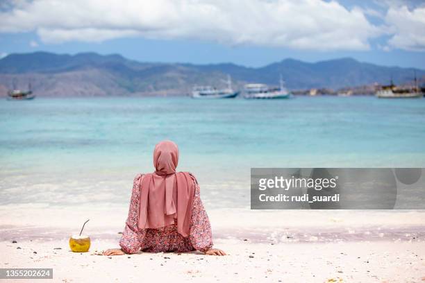 young asian woman enjoy vacation at pink beach in padar island, labuan bajo, nusa tenggara timur - coconut beach woman stock pictures, royalty-free photos & images
