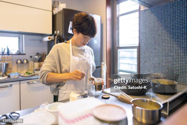 japanese woman putting mustard to a small bottle - savory sauce stock pictures, royalty-free photos & images