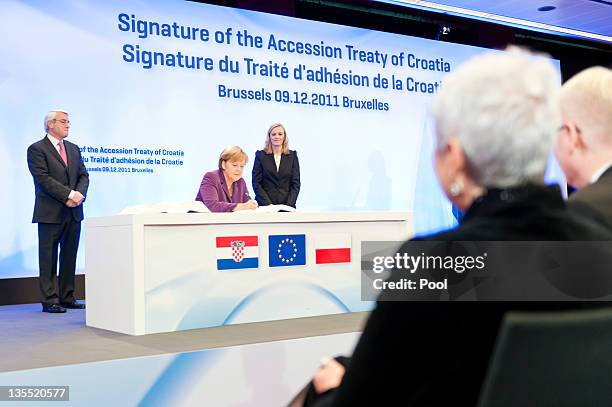 In this photo provided by German Government Press Office, German Chancellor Angela Merkel signs Croatia's EU accession treaty, on the sidelines of an...