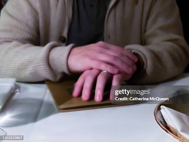 dad wearing wedding ring resting hands on menu while dining out with wife - a posh affair stock pictures, royalty-free photos & images