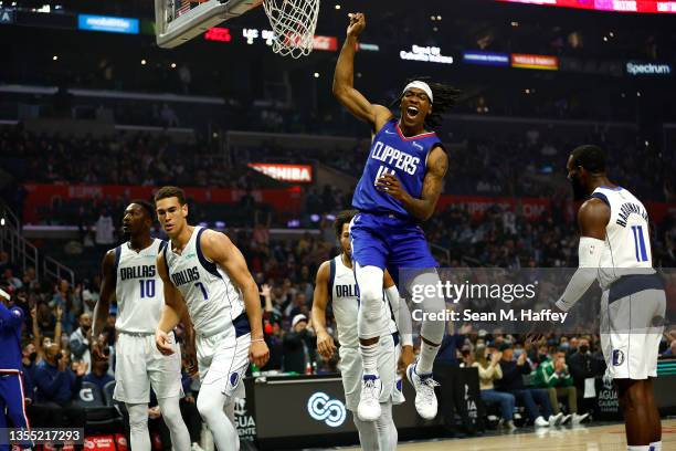 Terance Mann of the LA Clippers reacts after dunking the ball as Dorian Finney-Smith, Tim Hardaway Jr. #11 and Dwight Powell of the Dallas Mavericks...