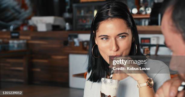 shot of a young woman enjoying a delicious milkshake at a diner with friends - tomando sorvete imagens e fotografias de stock