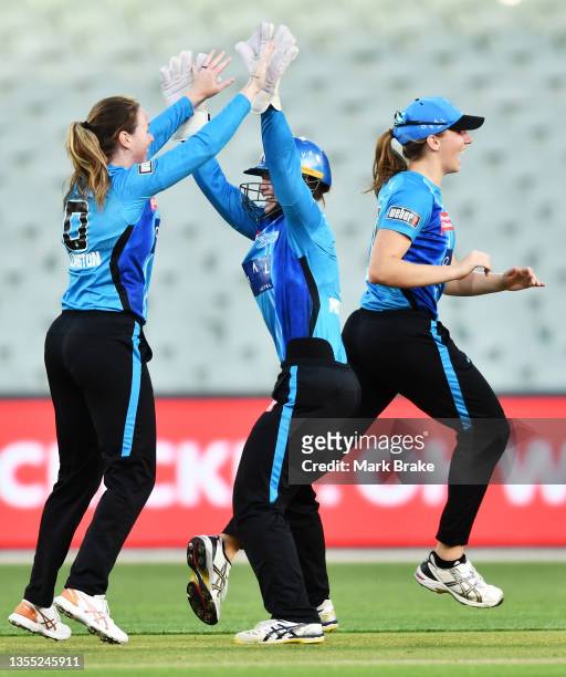 Amanda-Jade Wellington of the Adelaide Strikers celebrates the second wicket of a hatrick of Mikayla Hinkley of the Brisbane Heat with Tegan...