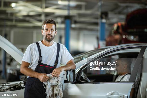junger mechaniker, der in der autowerkstatt arbeitet. - auto mechaniker stock-fotos und bilder