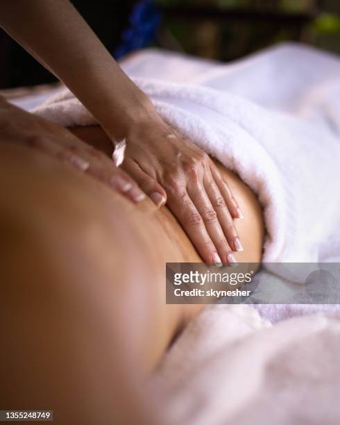 close up of a back massage at the spa. - rug handen zij stockfoto's en -beelden