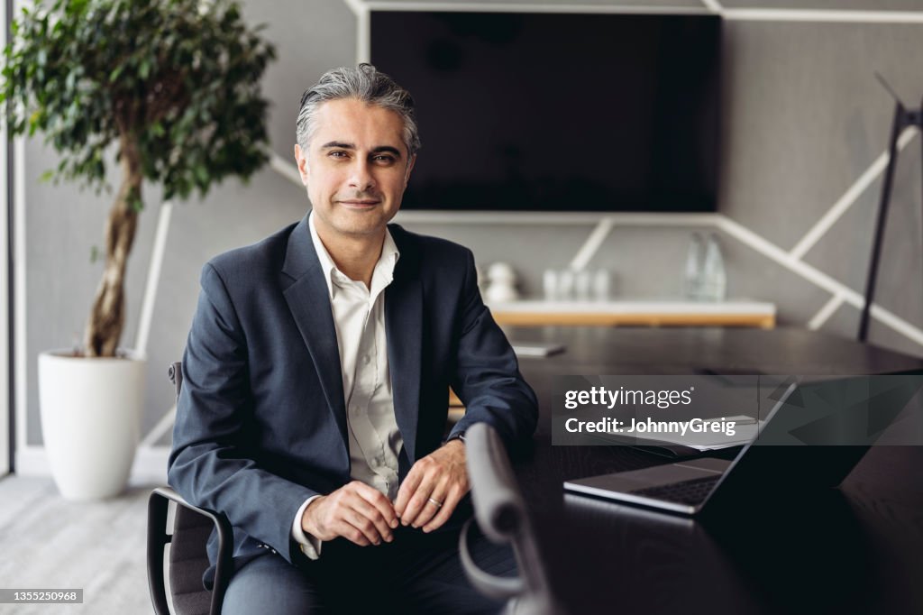 Portrait of Middle Eastern executive working in board room