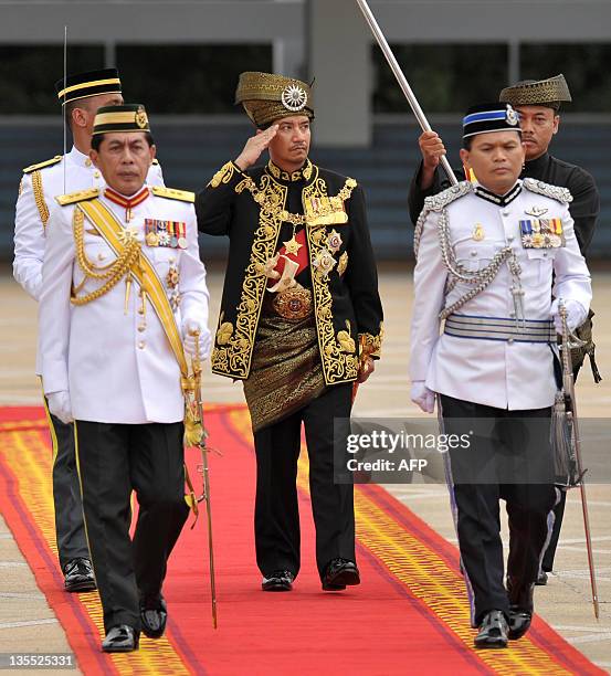 The outgoing 13th king of Malaysia, Tuanku Mizan Zainal Abidin , salutes the royal guard of honour during a farewell ceremony at the Parliment House...