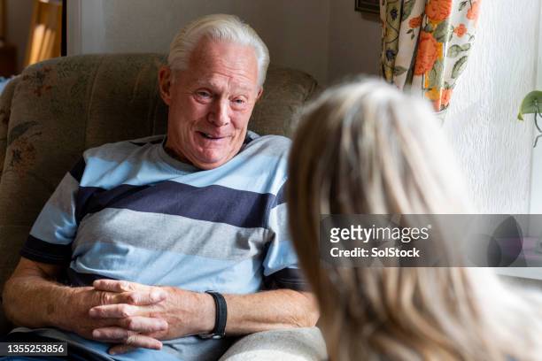 having a chat with a patient - caregiver and senior stockfoto's en -beelden