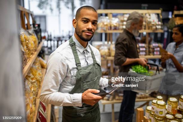 portrait of a sales clerk in a organic grocery store - shop assistant stockfoto's en -beelden