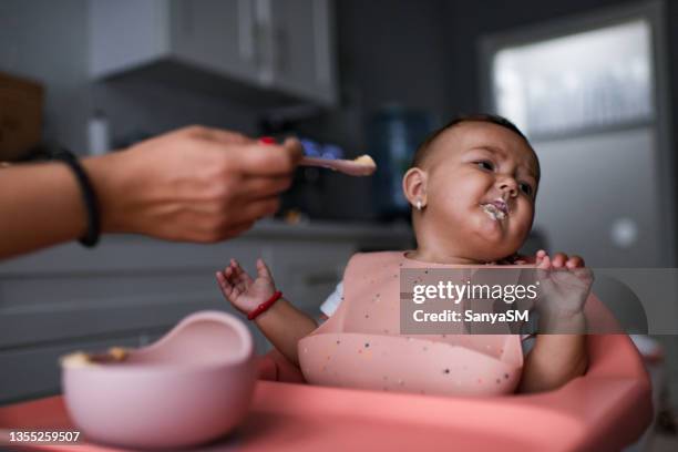 baby sitting in highchair refusing to eat - baby eating food imagens e fotografias de stock