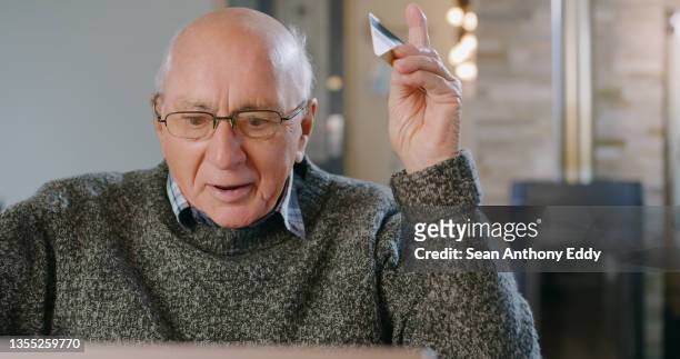 shot of a senior man using a credit card and laptop at home - debt free stock pictures, royalty-free photos & images