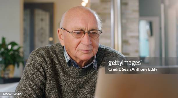 tiro de um homem idoso usando um laptop em casa - idoso na internet - fotografias e filmes do acervo