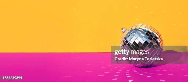 gray disco ball on an orange-pink background. - silver disco ball stock pictures, royalty-free photos & images