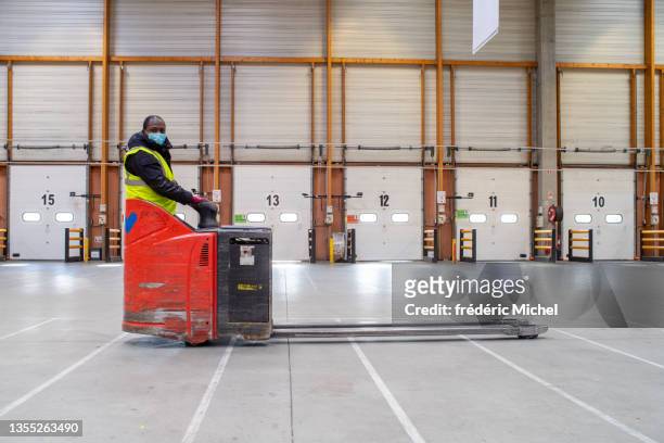 a wagon driver with a mask in a hangar - pallet jack stock pictures, royalty-free photos & images